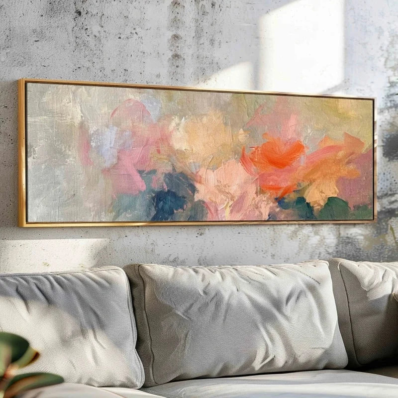 Abstract floral painting with a gold frame above a sofa on a textured wall.