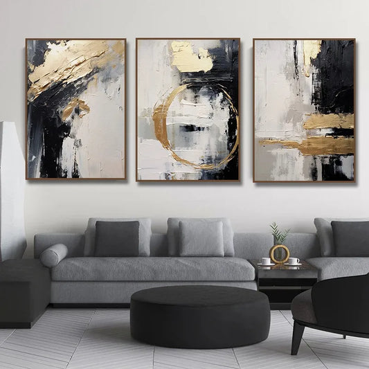 Three abstract art pieces in a living room setting with a gray sofa and black ottoman.