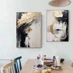 Two abstract paintings on a wall above a dining table with fruit and candles.