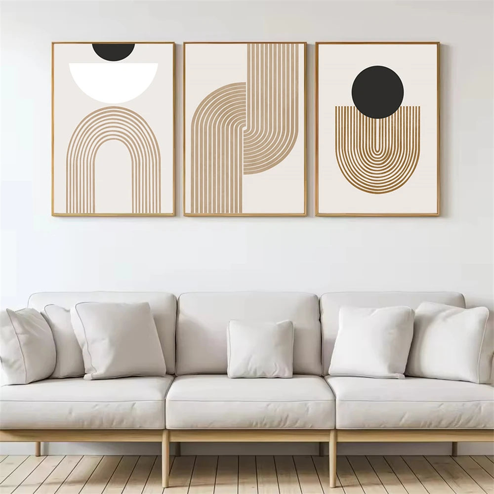 Three abstract wall art pieces above a white sofa in a minimalistic living room.