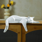 White geometric cat sculpture on a wooden surface with a blurred background
