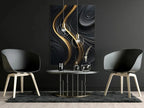 Modern interior with two black chairs and a table against a dark wall with abstract art.