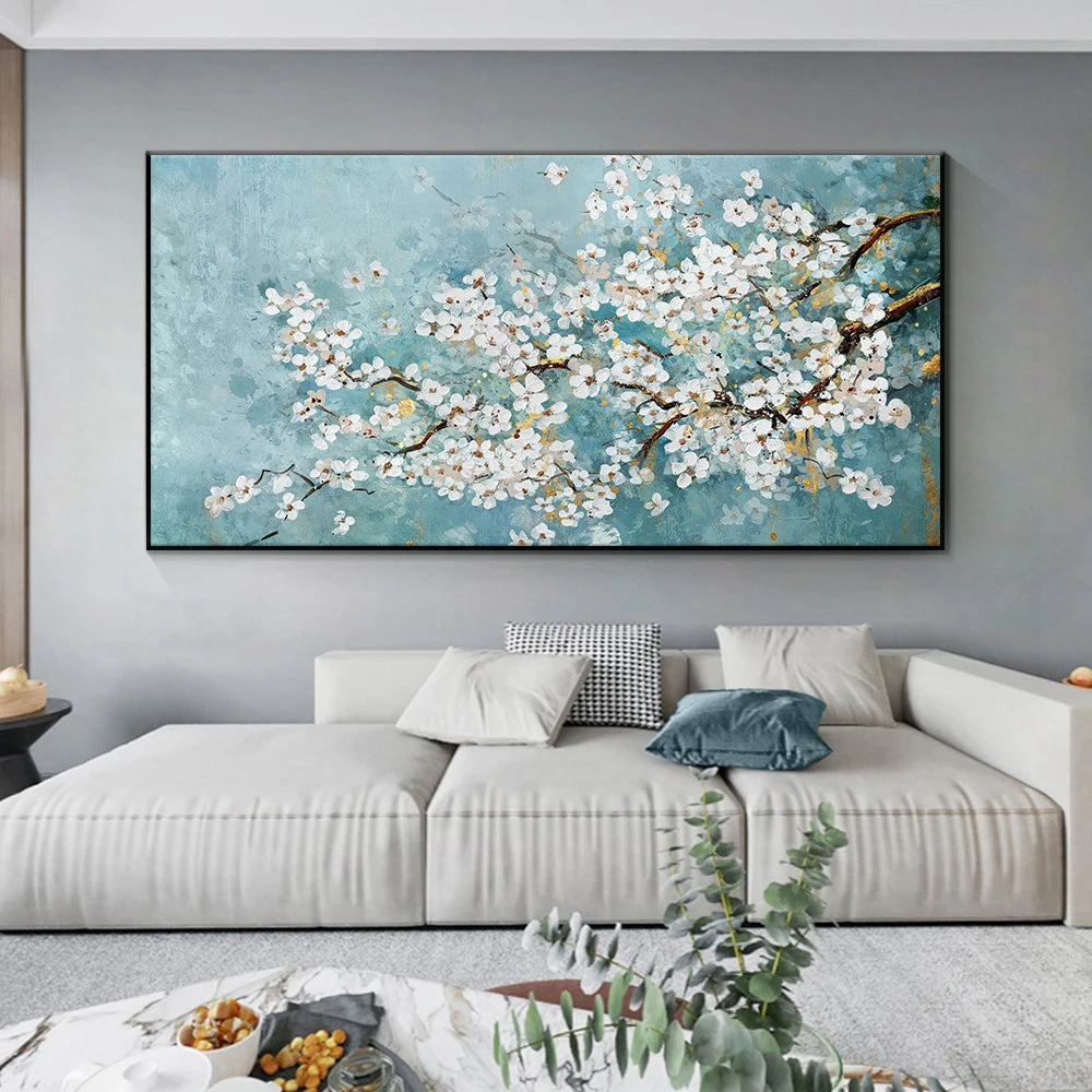 Framed artwork of cherry blossoms on a wall above a sofa in a living room.