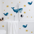 Bathroom with whale and star wall decals on a white wall.