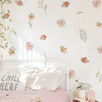 Floral wallpaper with a 'Chill Here' pillow on a bed