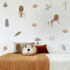 Children's room with lion-themed wall decals and decorative pillows on a bed.