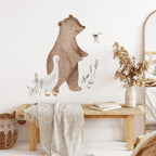 Room interior with a large bear wall decal, goose figurine, and decorative plants.