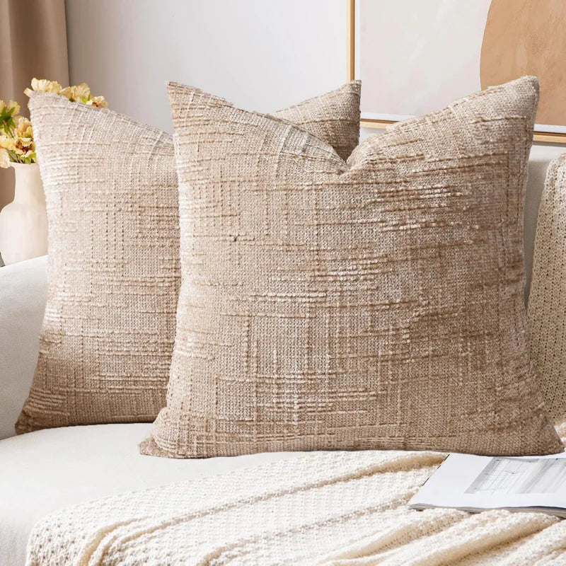 Textured beige pillows on a bed with a neutral background