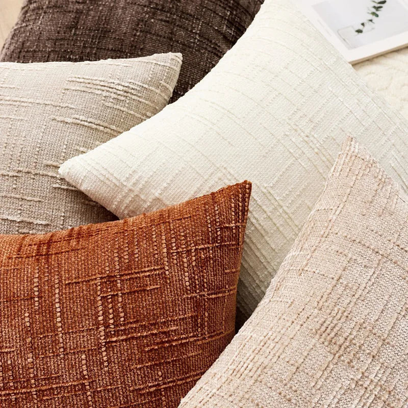Close-up of textured pillows in neutral colors on a surface.