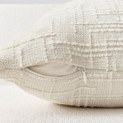Textured beige pillow with a zipper on a light background