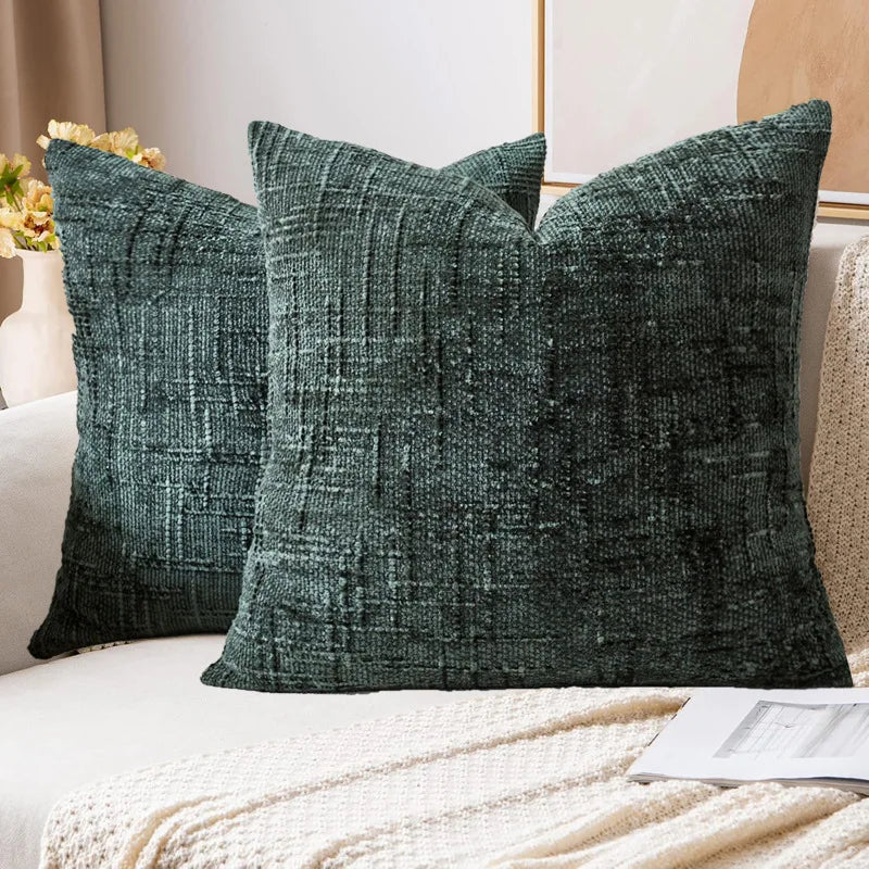 Two green textured pillows on a sofa with a neutral background