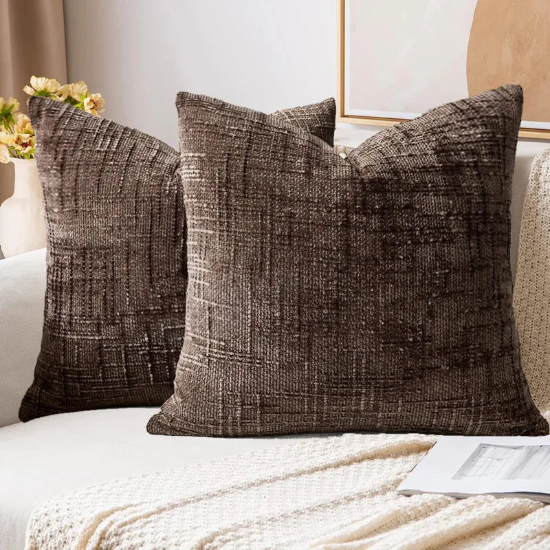 Textured brown throw pillows on a sofa with a neutral background