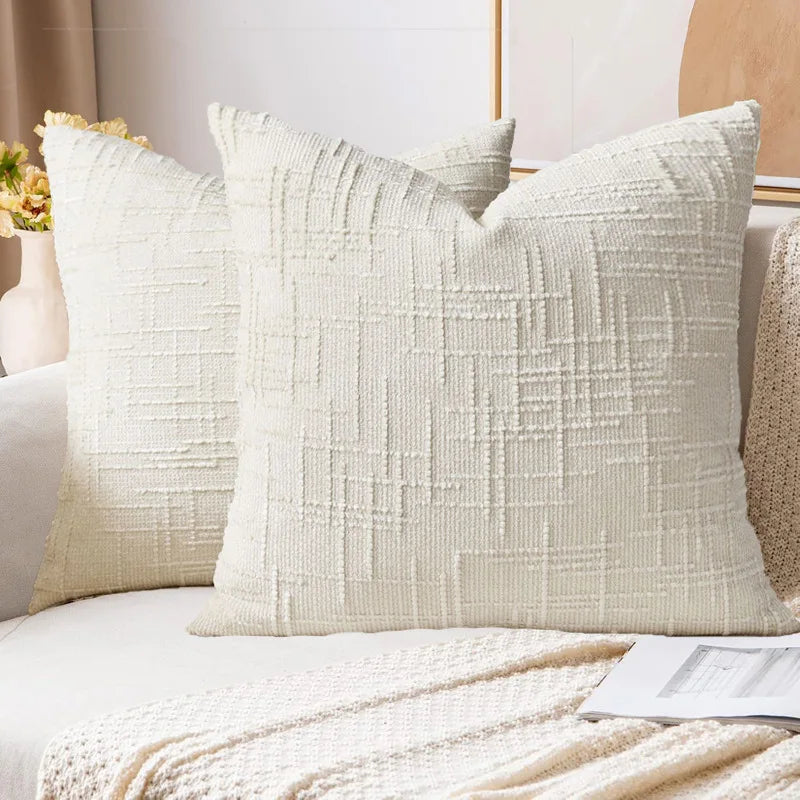 Textured throw pillows on a sofa with a neutral background