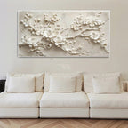 White floral wall art above a beige sofa in a living room.