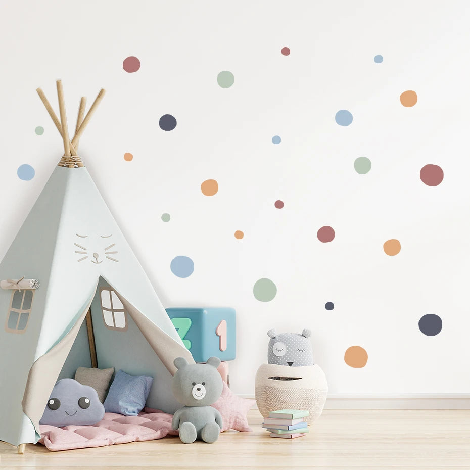 Children's playroom with a teepee, toys, and polka dot wall stickers.