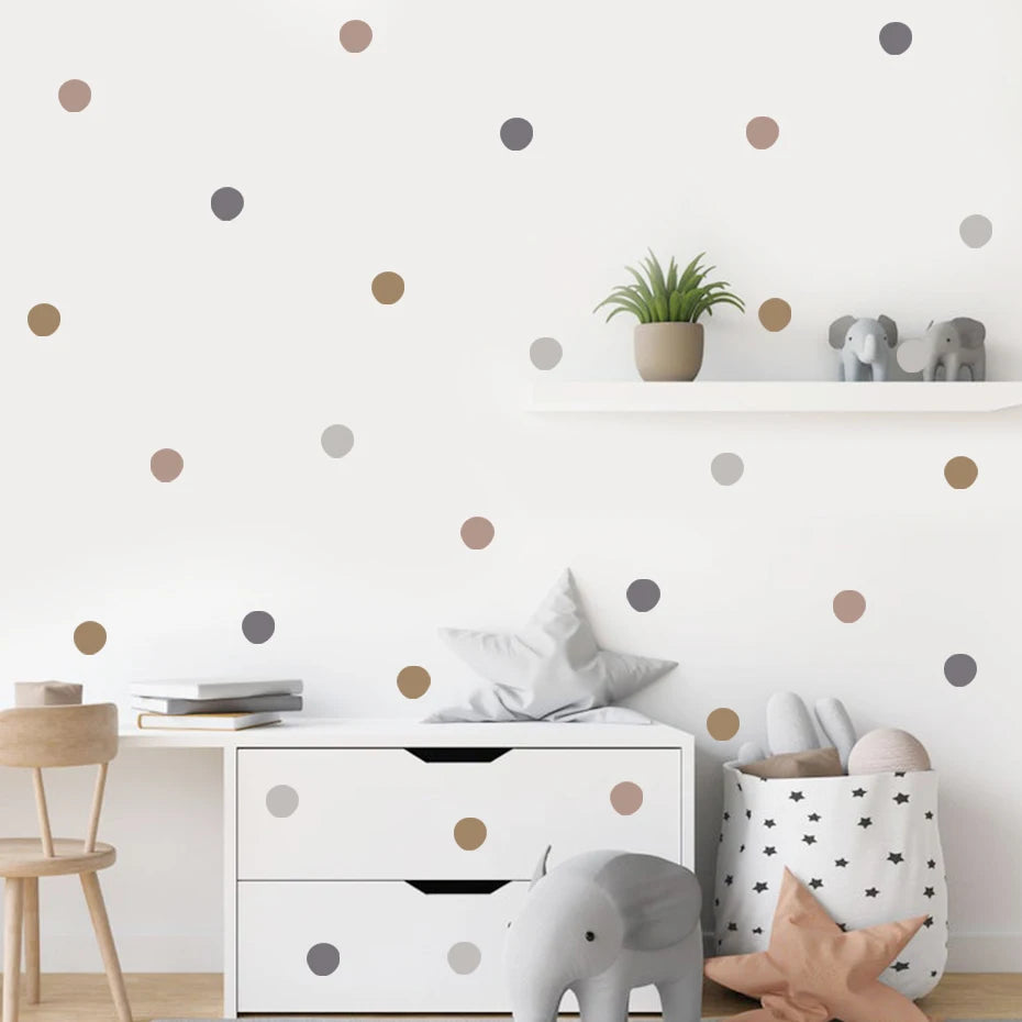 Children's room with polka dot wall decals, white dresser, and toys.