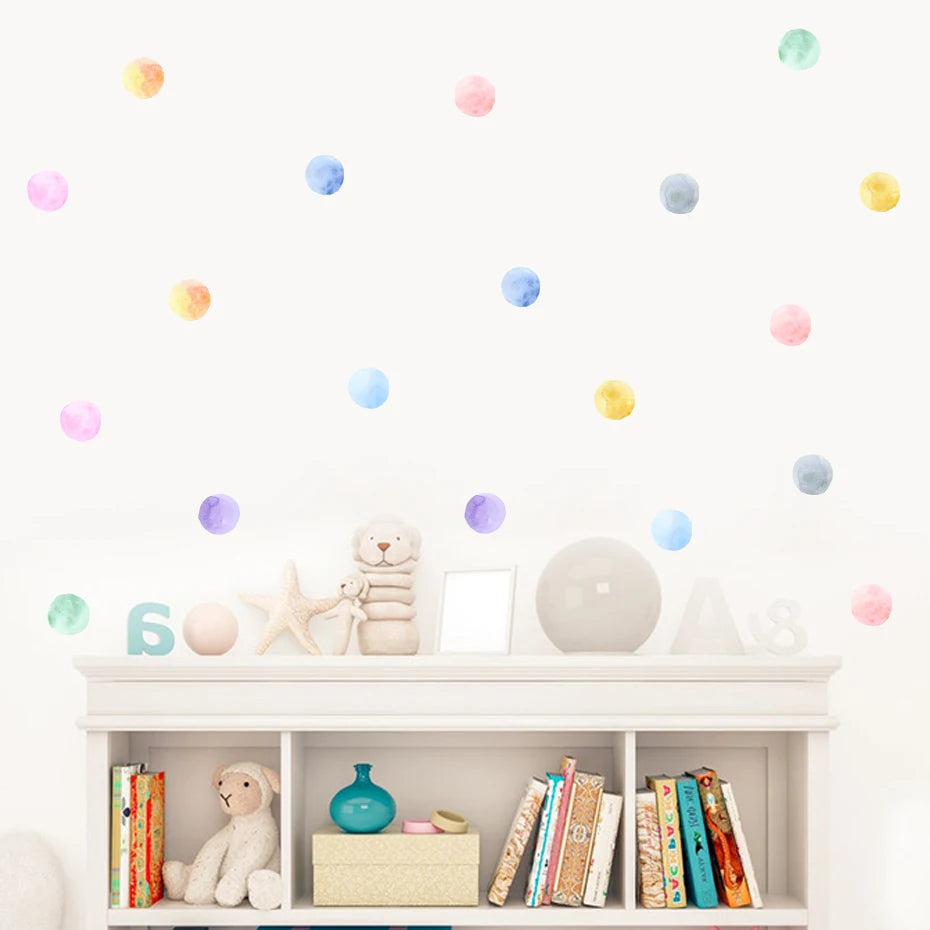 White shelf with books and toys decorated with colorful polka dot wall stickers.
