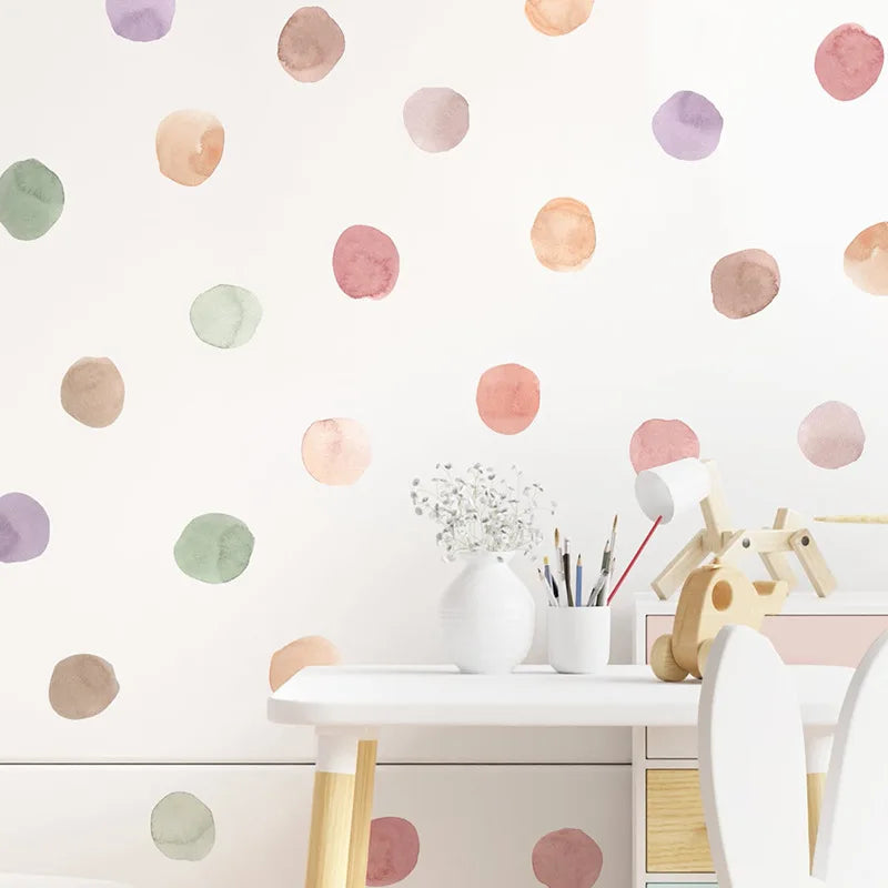 Children's play area with a white table and chairs against a wall with colorful polka dot decals.