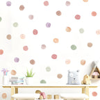 Children's room with pastel polka dot wall decals, toys, and a plant.