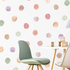 Children's room with polka dot wall, green chair, and wooden blocks.