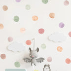 Plush toy bat with a clock on a polka dot background