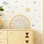 Wall with a rainbow and cloud decal above a wooden cabinet