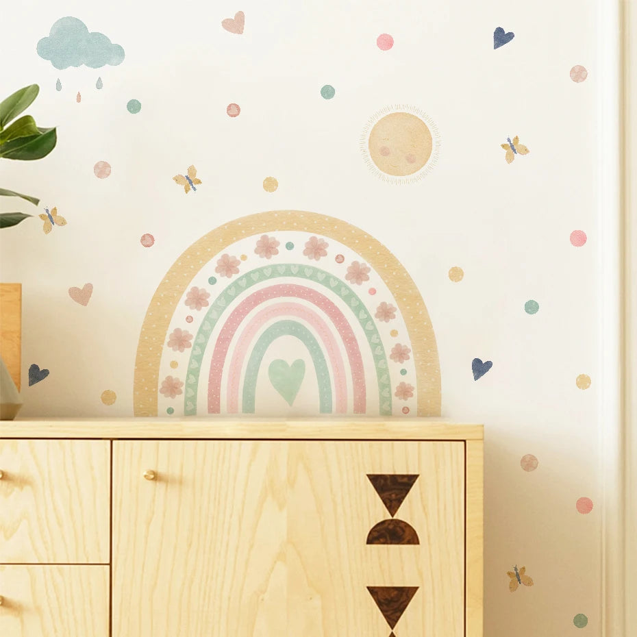 Wall with a rainbow and cloud decal above a wooden cabinet