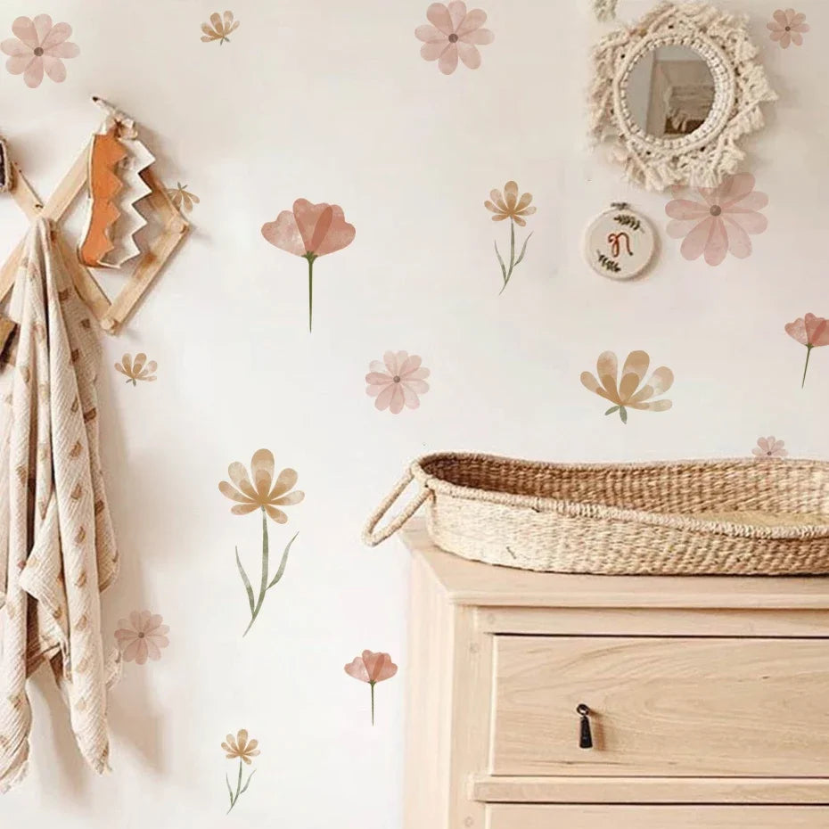 Nursery room with floral wall decals, wooden dresser, and baby blanket.