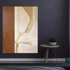 Abstract art piece on a dark wall with a small round table and plant.