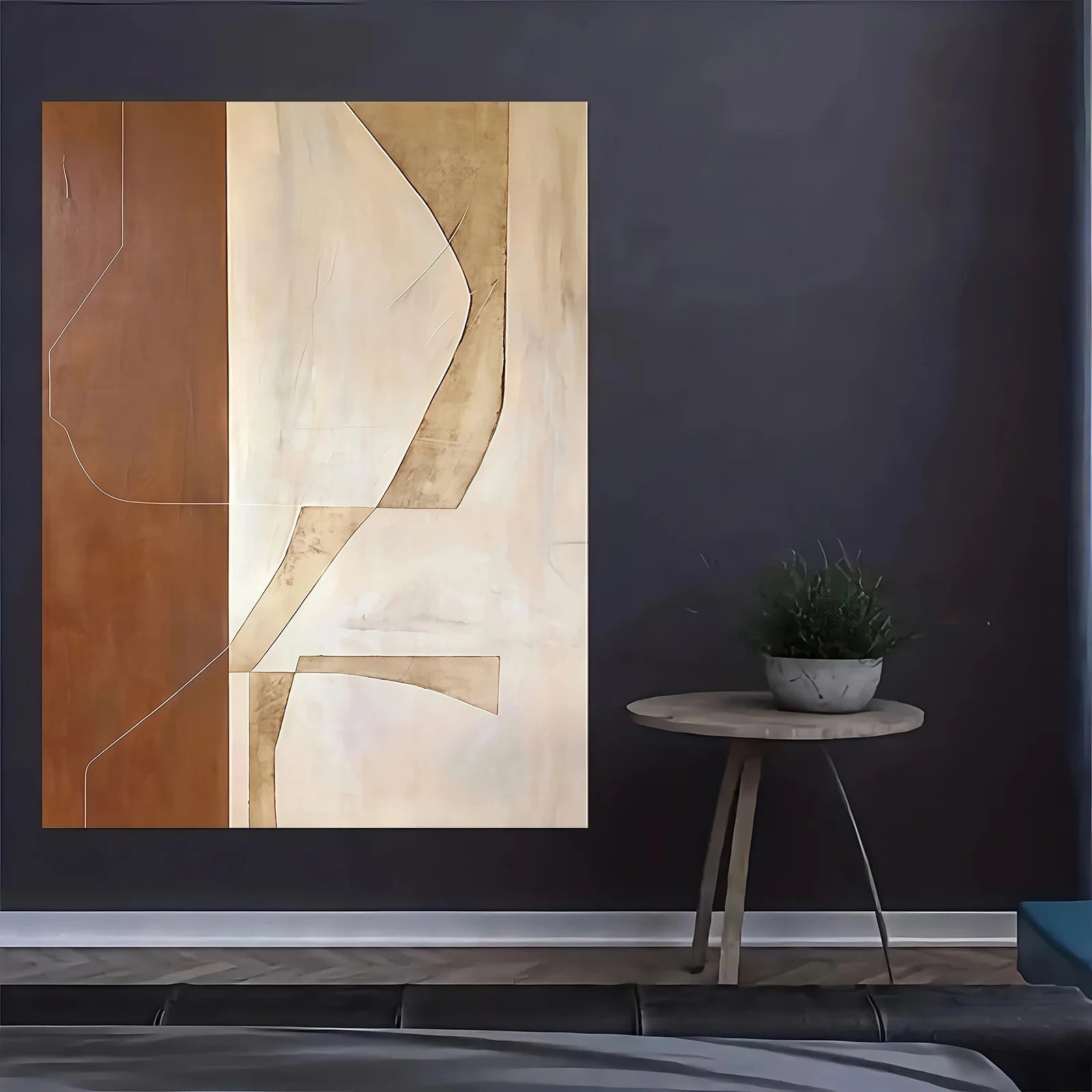 Abstract art piece on a dark wall with a small round table and plant.