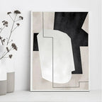 Abstract art print with black, white, and gray shapes on a white wall.