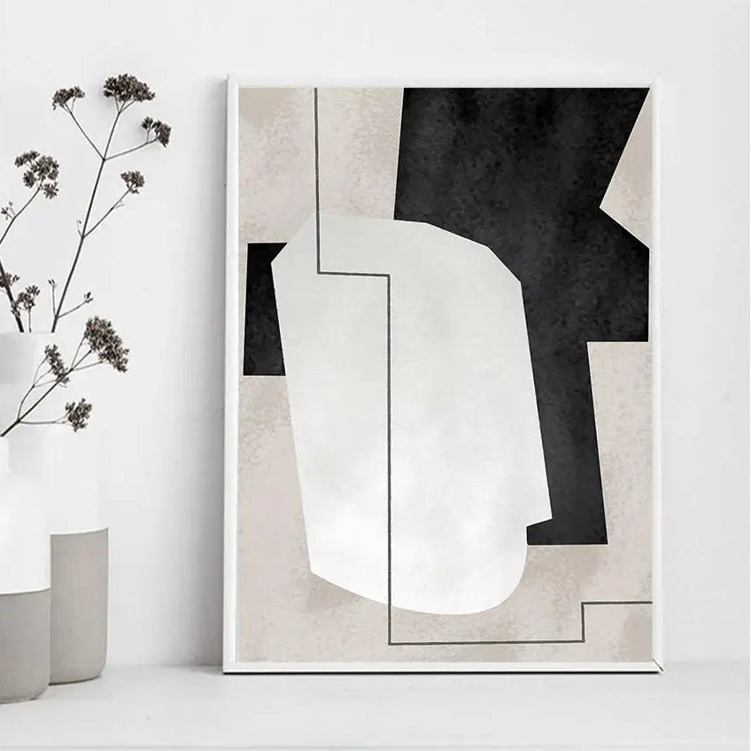 Abstract art print with black, white, and gray shapes on a white wall.