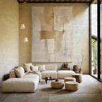 Modern living room with a large abstract painting on the wall, beige sofa, and wooden coffee tables.