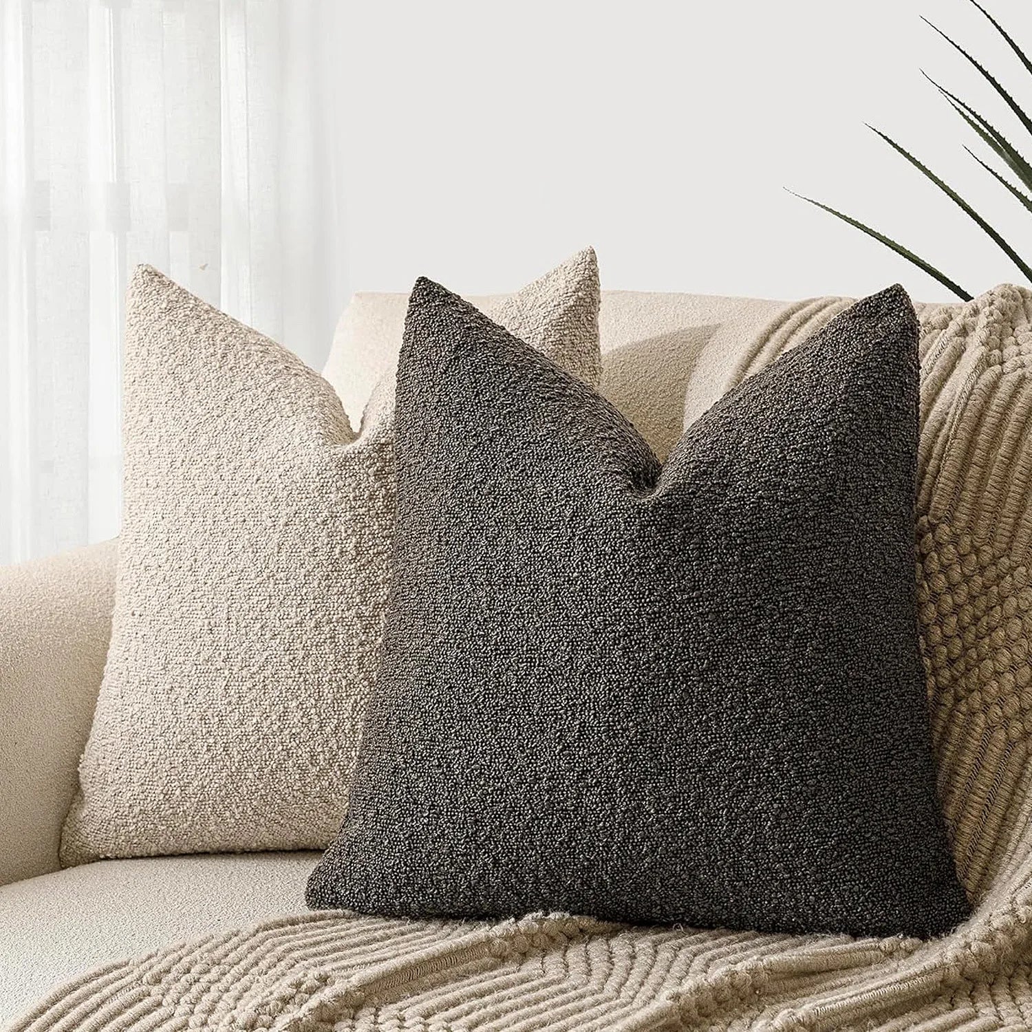 Textured throw pillows on a sofa with a neutral background