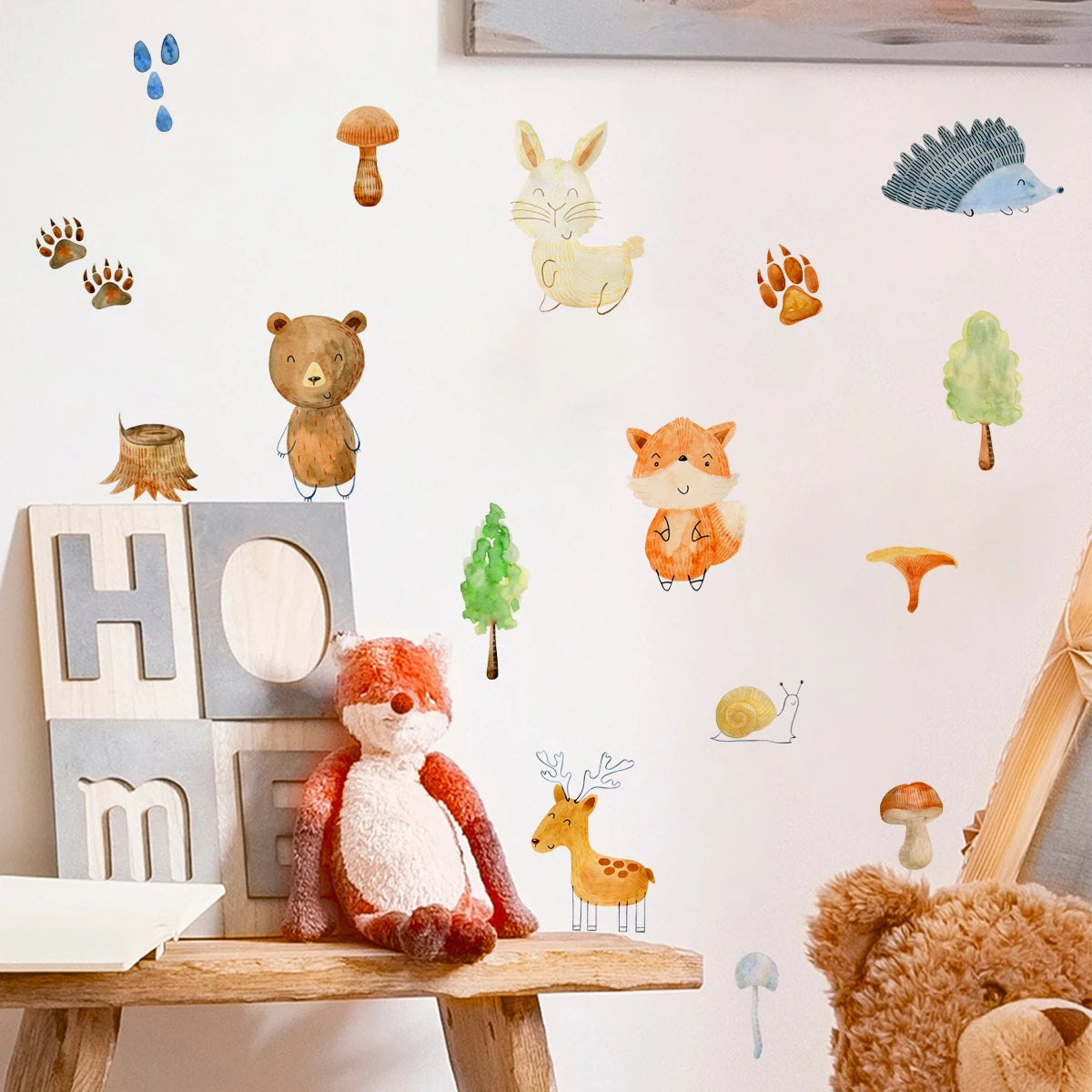 Children's room with forest-themed wall decals and plush toys.
