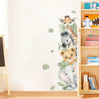 Wall decal of jungle animals on a wall next to a wooden bookshelf with books.
