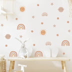 Children's room with decorative wall stickers of suns, moons, stars, and rainbows on a white wall.
