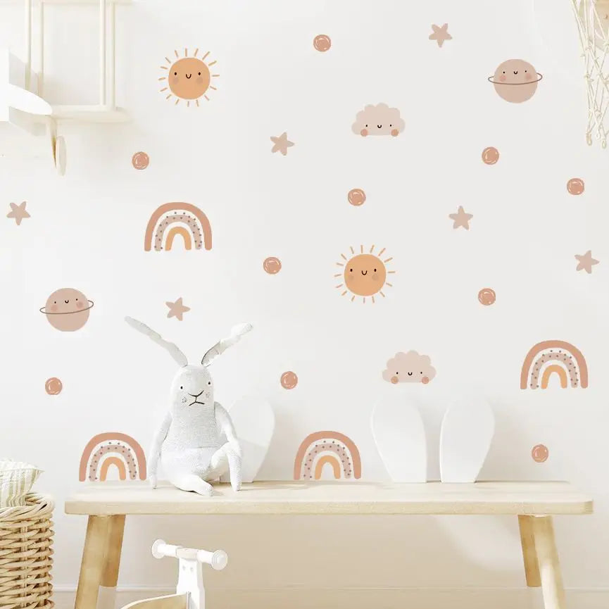 Children's room with decorative wall stickers of suns, moons, stars, and rainbows on a white wall.