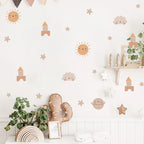Children's room with decorative wall stickers of suns, stars, and clouds.