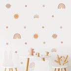 Children's room with wall stickers of suns, moons, stars, and rainbows above a small table and chairs.