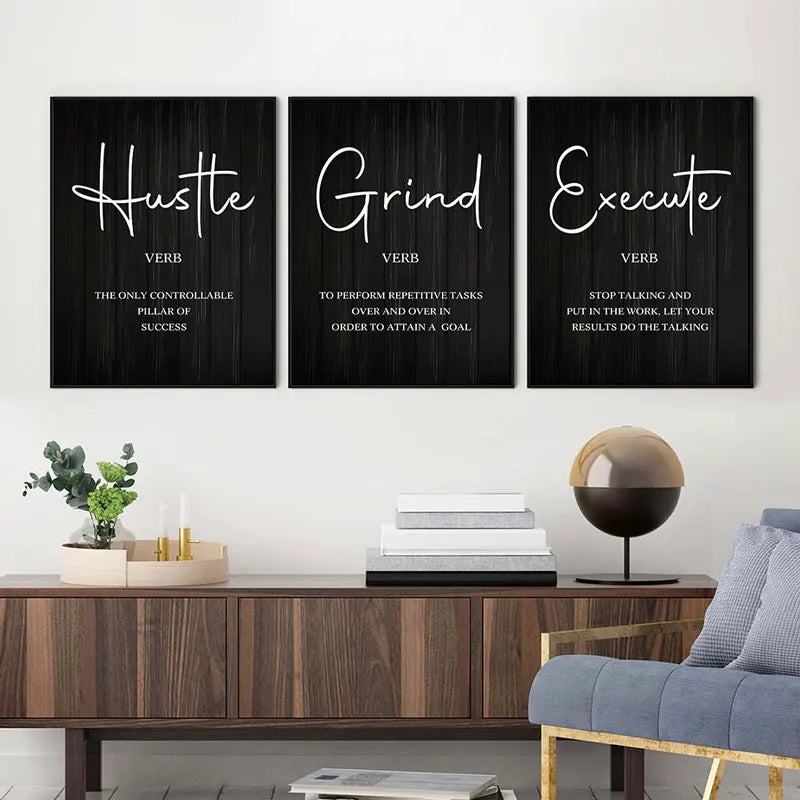 Three motivational posters on a wall above a wooden console table with decor items.