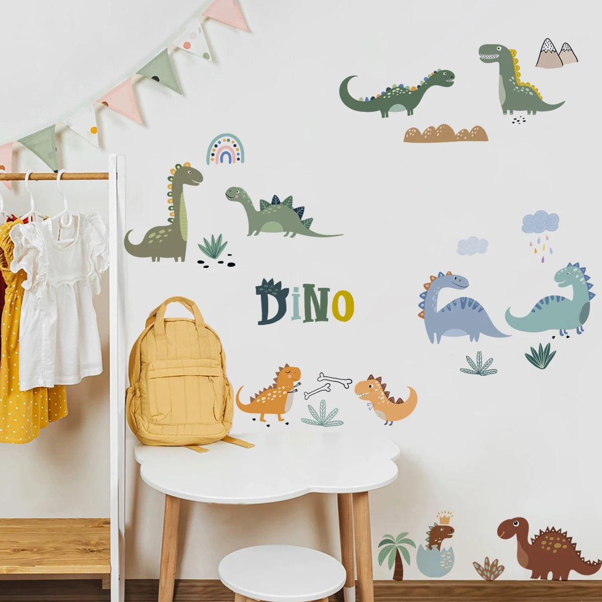 Children's room with dinosaur wall decals, a yellow backpack on a white stool, and clothes hanging on a rack.