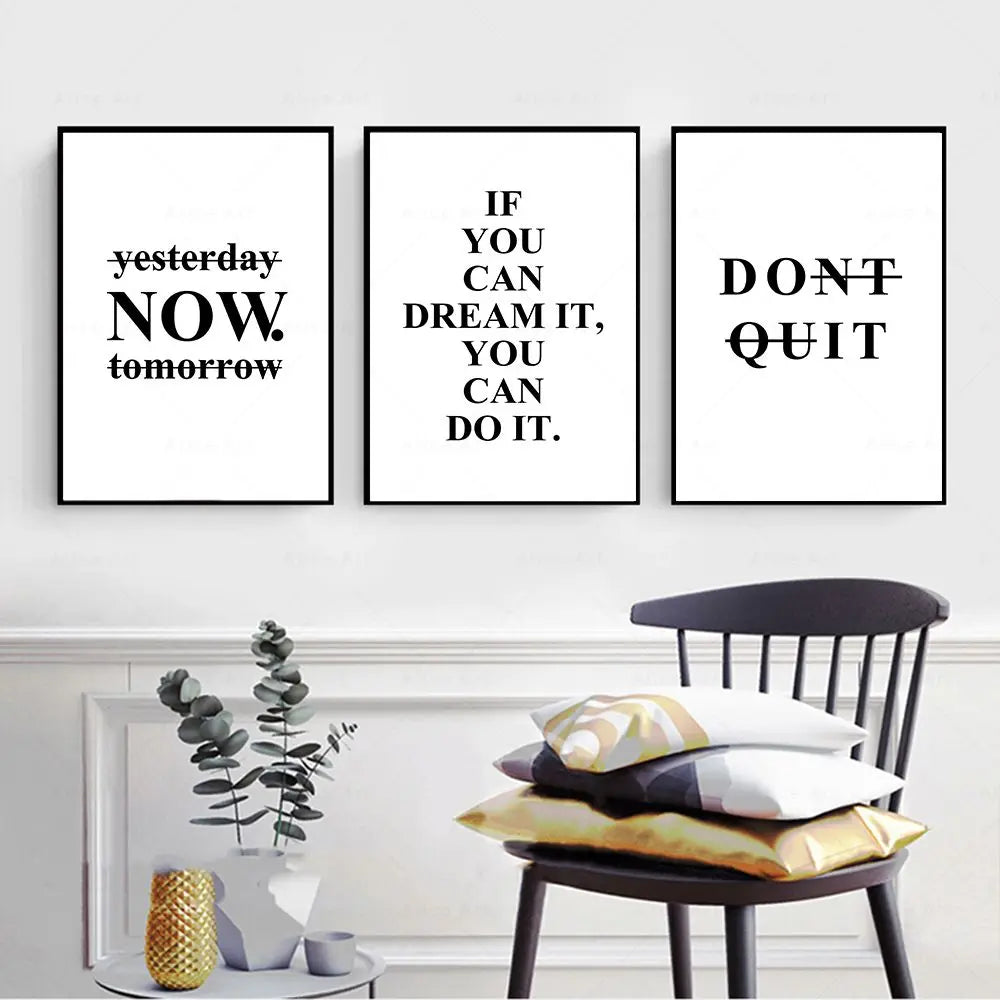 Three motivational posters on a wall with a chair and decorative items below.