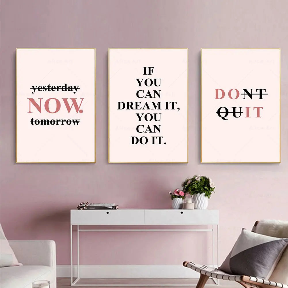 Three motivational posters on a wall with a white console table and chair below.