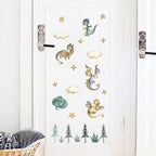 Decorative wall stickers of dragons, trees, and clouds on a white door.