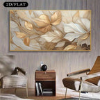 A wall art print featuring an abstract floral design with layered leaves in beige, cream, and gold tones, displayed in a modern living room setting above a wooden side table and between two armchairs.