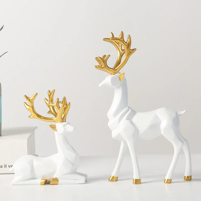 White deer figurines with gold antlers on a light gray background