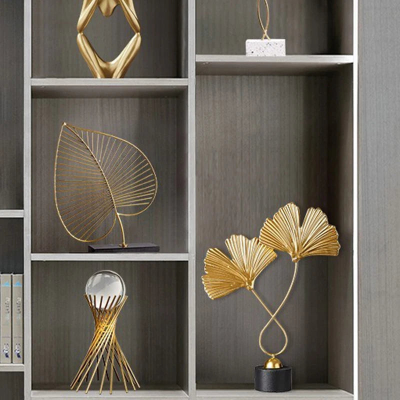 Decorative gold sculptures on a wooden shelf
