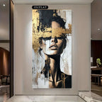 Abstract art piece of a woman's face with gold accents on a wall in a modern interior setting.