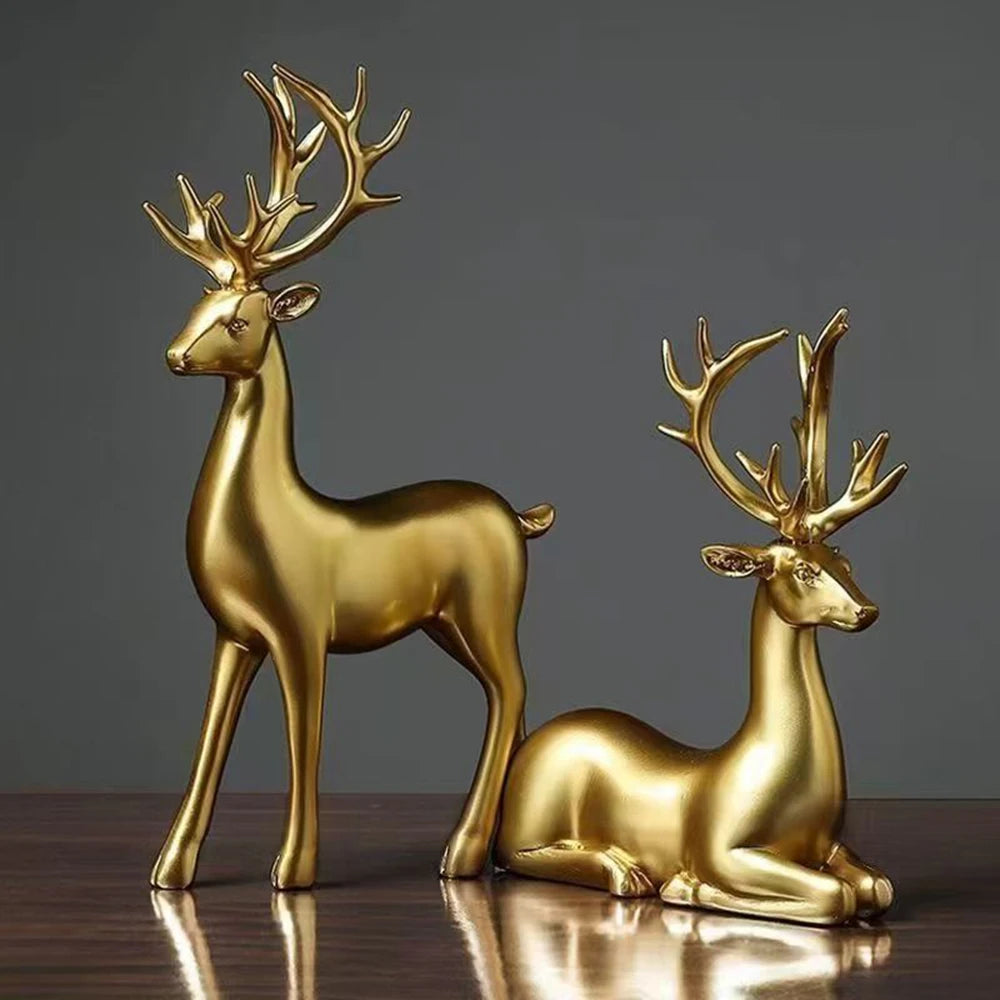 Two gold deer figurines on a reflective surface with a dark background